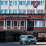 Quality Hotel Bodensia med polisbil utanför och Espresso House vid entrén, träd utan löv.