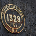 Gammal Statens Järnvägar-skylt med nummer 1329 och år 1917 på rostig metall.